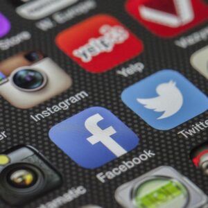 Close-up image of various social media app icons on a smartphone screen.